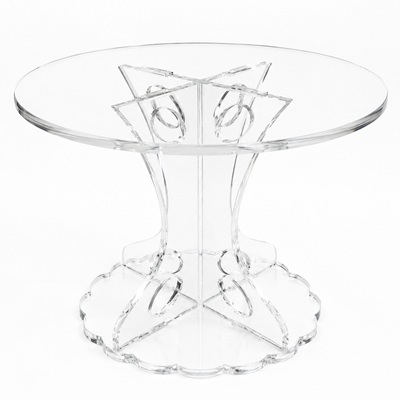 Round acrylic cake stand with a frosted celebration cake on top